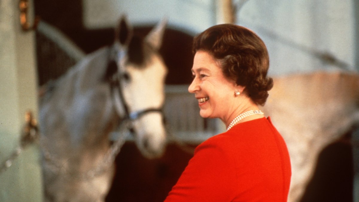 La reina Isabel II de Inglaterra sonrie mientras contempla unos caballos participantes en el Windsor Horse Show (Foto sin fecha, década años 80)