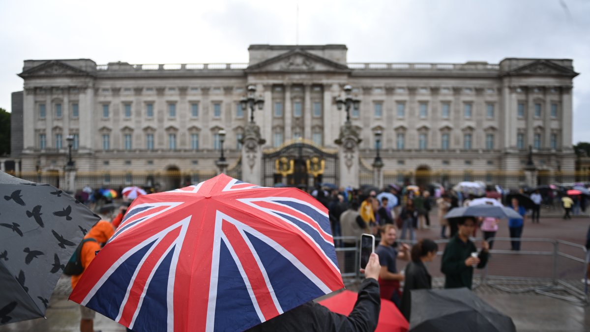 Un hombre hace una foto bajo la lluvia frente al Palacio de Buckingham en Londres este 8 de septiembre.