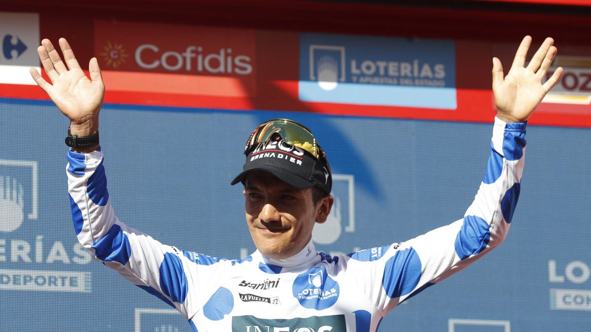 Richard Carapaz levanta los brazos con su maillot de puntos azules.