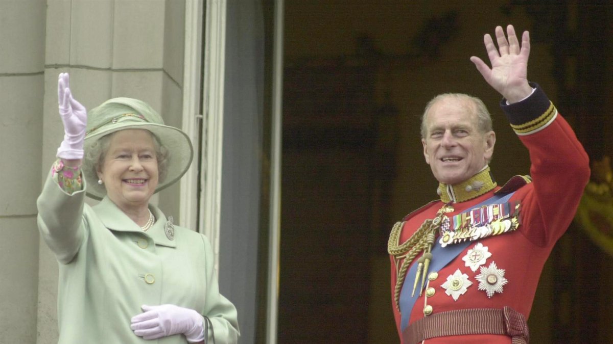 La reina Isabel II y el Duque de Edimburgo saludan desde el Palacio de Buckingham de Londres en junio de 2001.