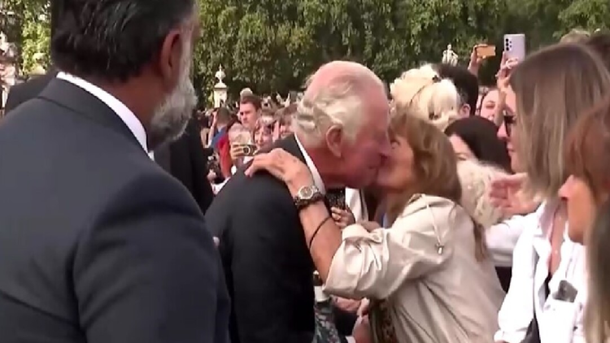 La mujer se inclinó sobre las barreras de seguridad para besar en la mejilla al rey Carlos III