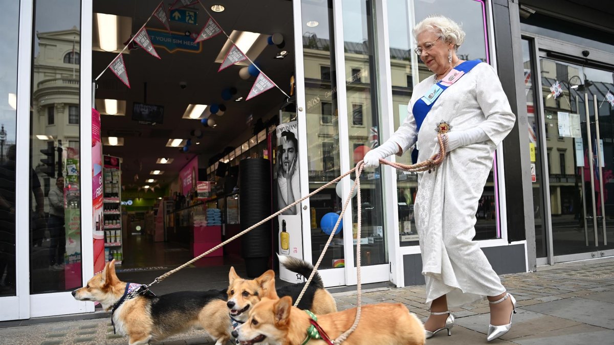 Imagen de archivo de una imitadora de Isabel II y sus perros paseando por Londres.