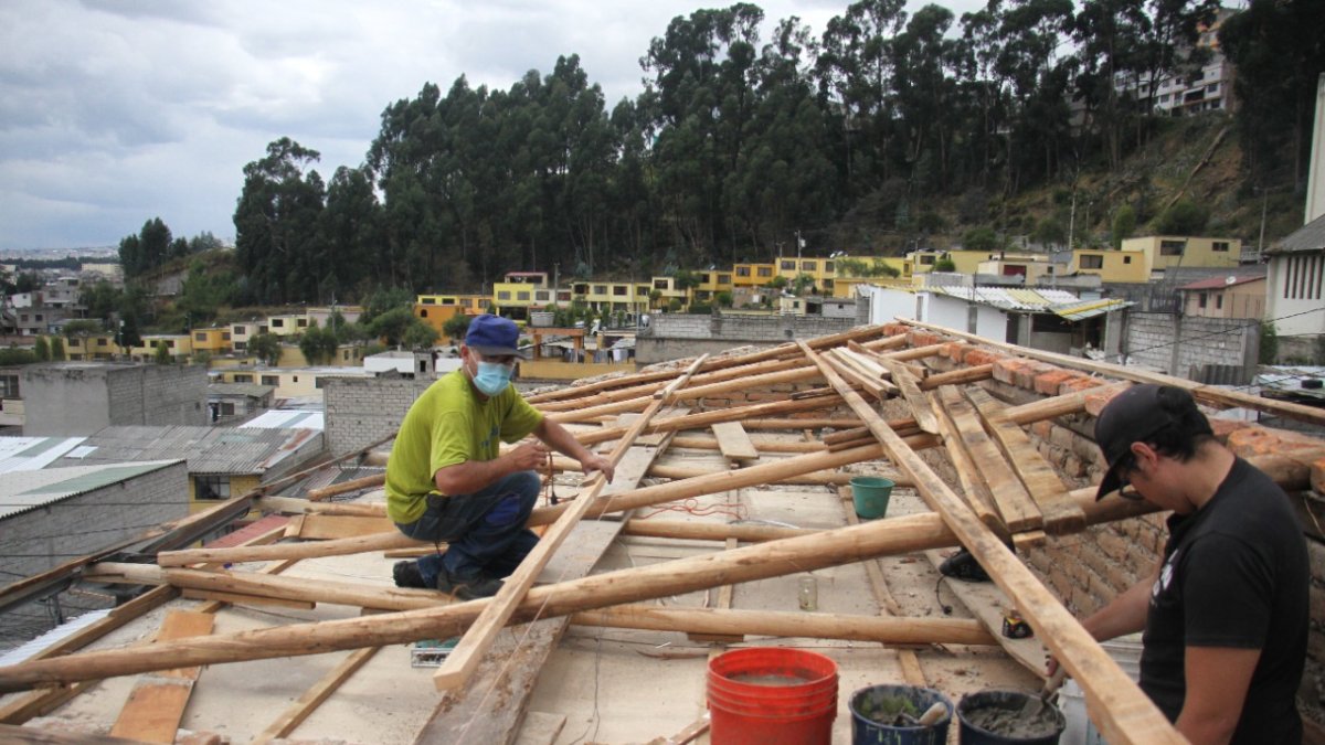 Reparación. Los hijos de una de las afectadas por el temporal reparan los techos.