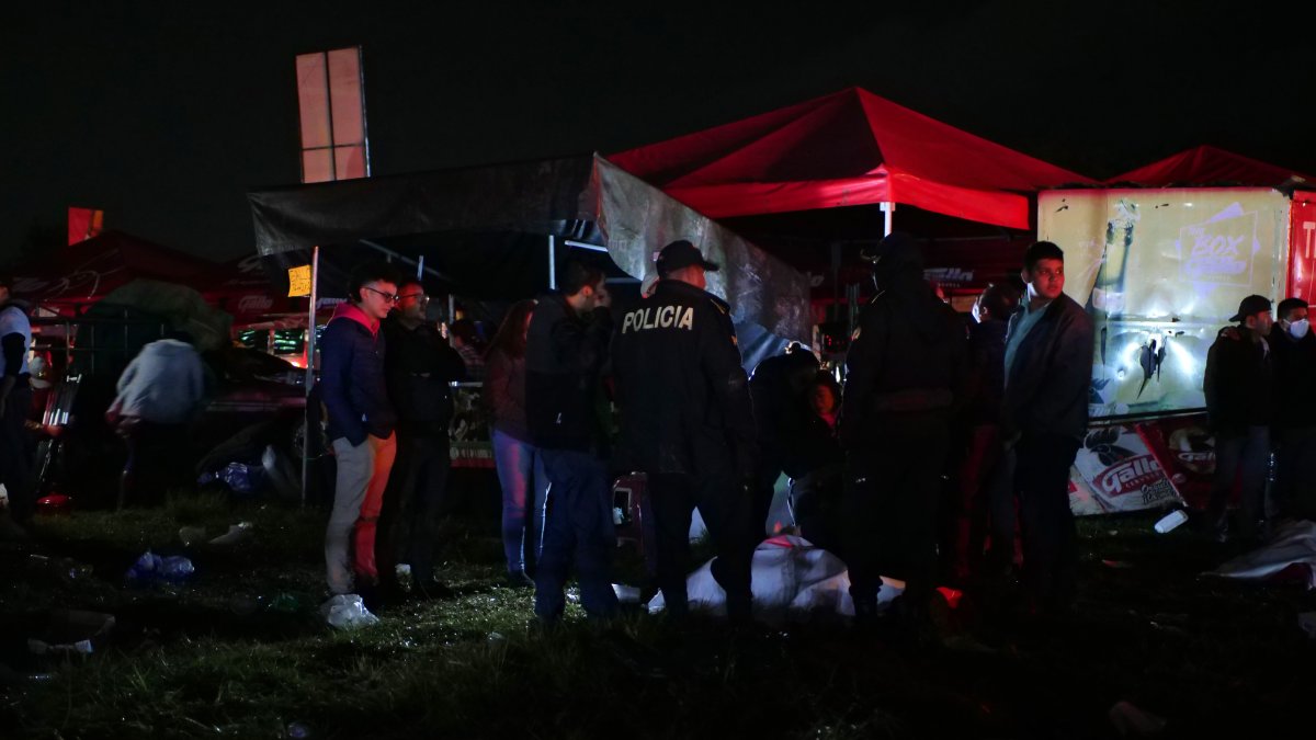Agentes de policía resguardan los cuerpos de algunas víctimas tras una estampida en la madrugada de este jueves 15 de septiembre de 2022, en Quetzaltenango (Guatemala).