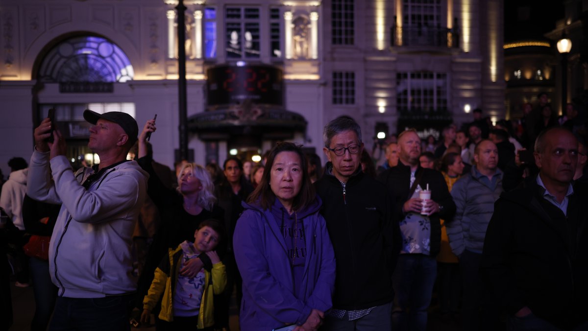 Un grupo de personas guardan un minuto de silencio por la reina Isabel II en Piccadilly Circus en Londres