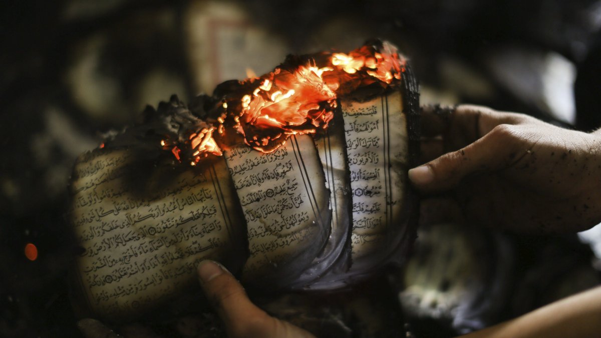 Panorama. Un hombre muestra un ejemplar del Corán en llamas en una mezquita que fue incendiada en Cisjordania en noviembre de 2014.