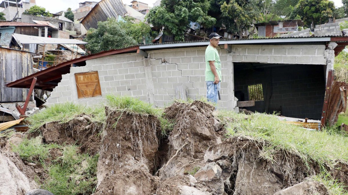 Familias observan los daños dejados por las lluvias, en Tegucigalpa (Honduras).
