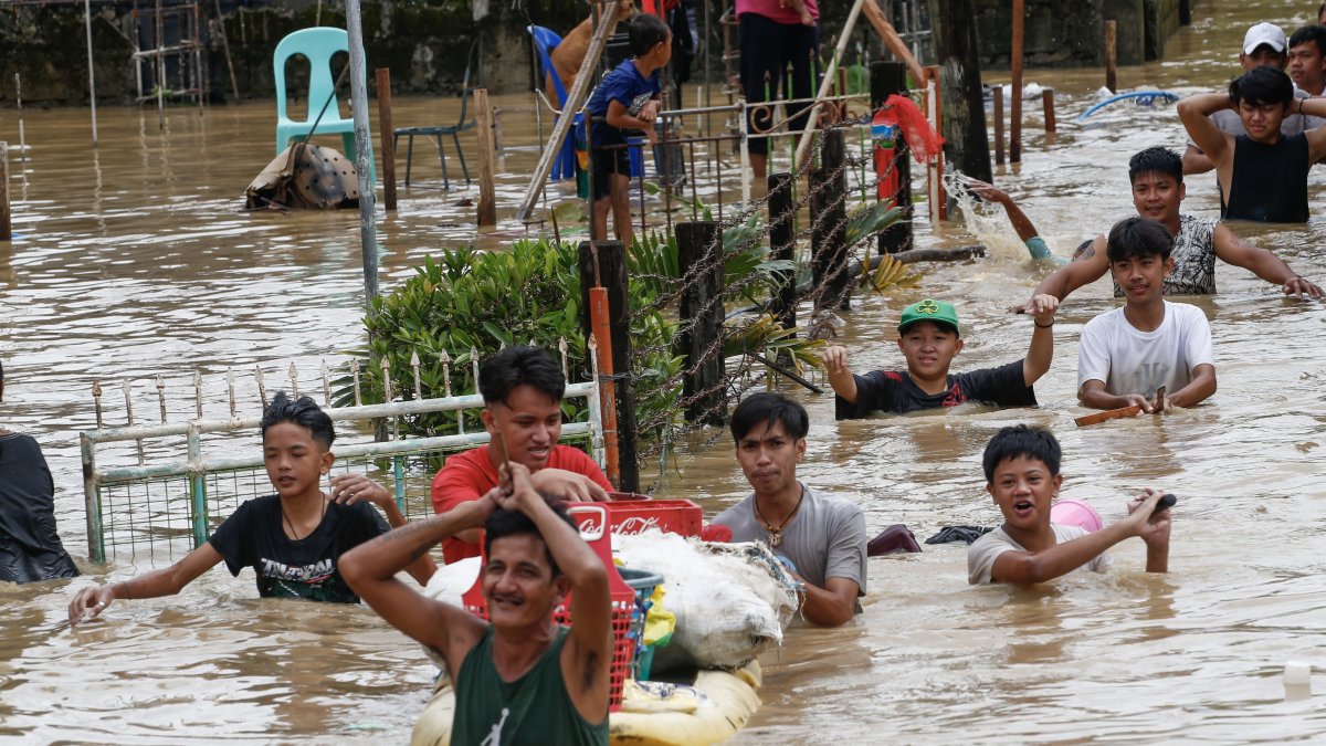 Ciudadanos caminan con el agua hasta la cintura debido a la inundación provocada por el tifón Noru en la localidad de San Miguel de Bulacan, en la isla de Luzón, Filipinas. EFE/