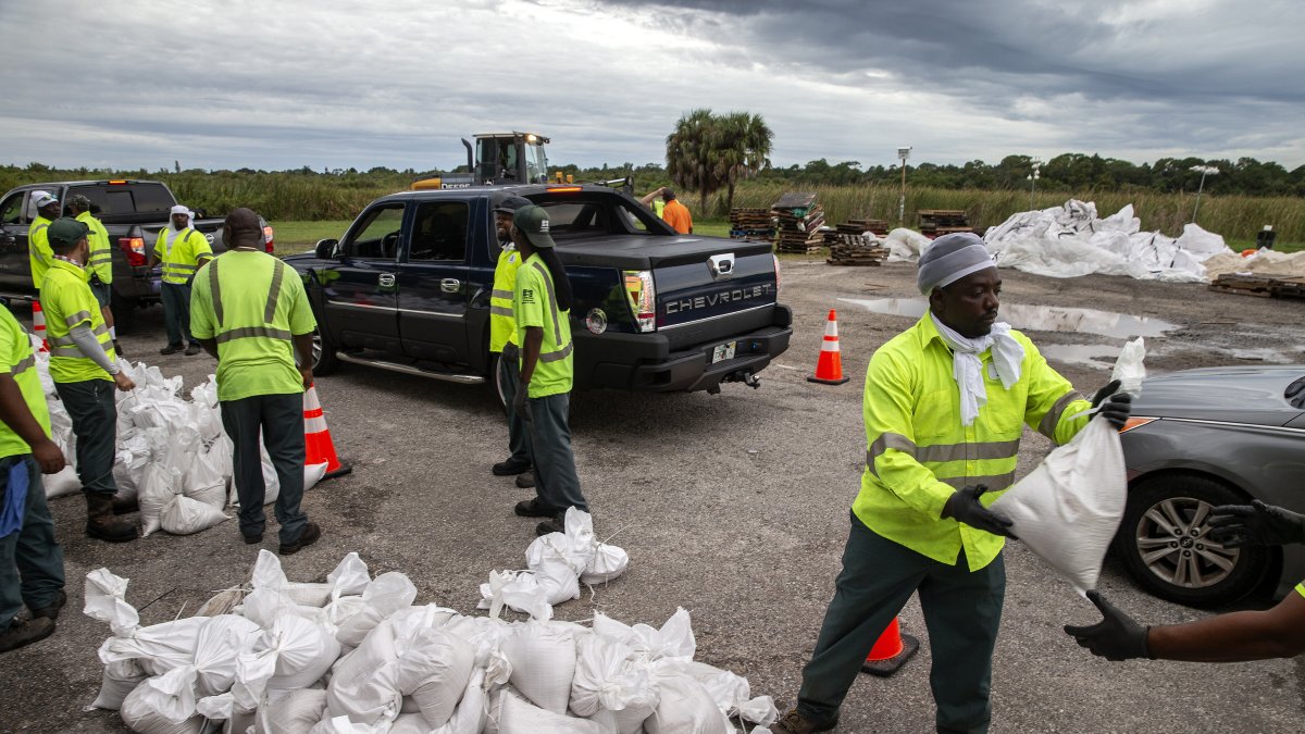 Trabajadores y voluntarios de la ciudad de San Petersburgo entregan sacos de arena  a los residentes, mientras la gente se prepara para el huracán Ian en Florida,