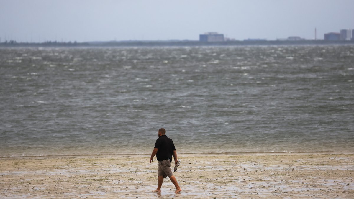 Un hombre camina a lo largo de una costa en Tampa, Florida, EE. UU., el 28 de septiembre de 2022.