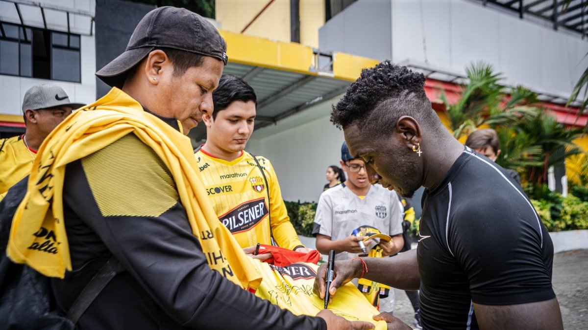 Erick Castillo jugador amarillo firmando autógrafos a varios socios del Barcelona.