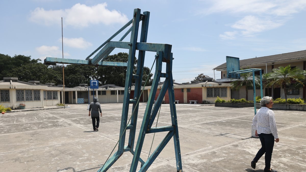 En ruinas. Dos personas recorren la zona de canchas del complejo de Asenir. Los pocos alumnos que hay no las usan por el deterioro.