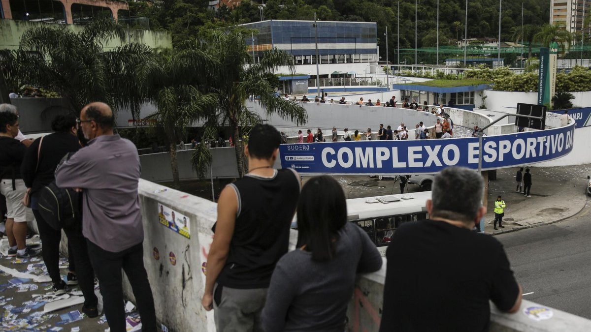 Ciudadanos brasileños esperan en una fila para votar en un centro de votación hoy, en Río de Janeiro (Brasil).