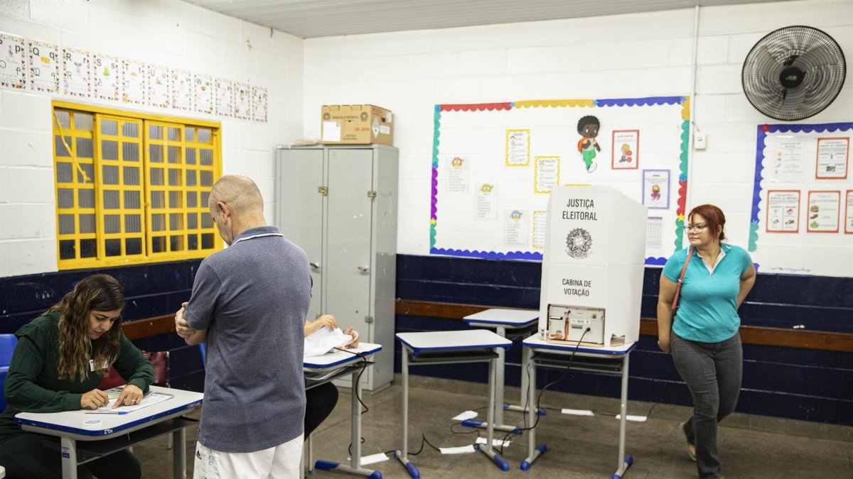 Ciudadanos brasileños llegan a una mesa de votación hoy, en una escuela de Brasilia (Brasil)
