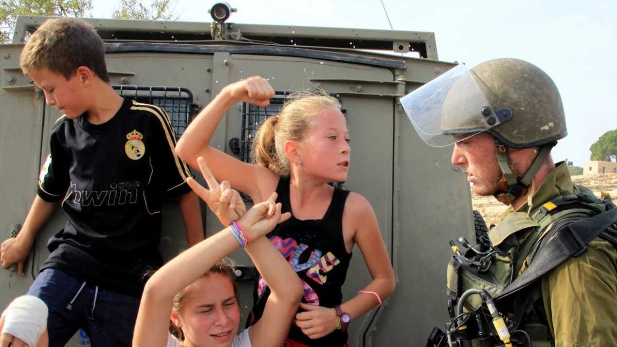 La niña palestina Ahed Tamimi (centro) desafía a los soldados israelíes durante una protesta en Cisjordania.