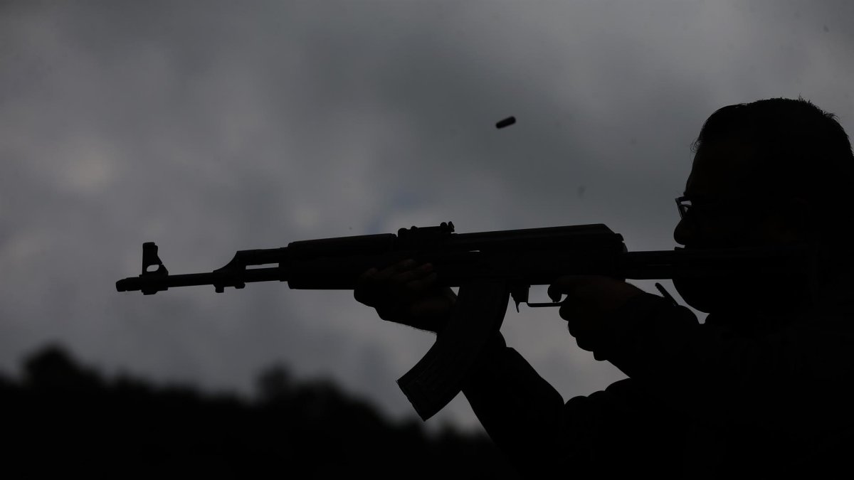 Fotografía de archivo, tomada en julio de 2021, en la que se registró a un hombre al disparar un arma de fuego, durante una prueba balística, en Ciudad de México (México).