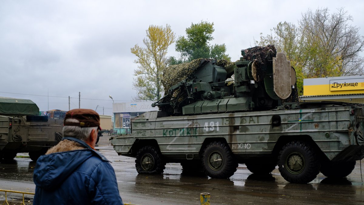 Un hombre observa un vehículo militar ruso destruido en la localidad de Kupiansk.