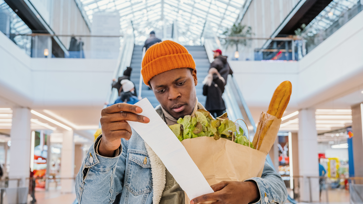 Compra.- Una persona revisa la factura de lo que adquirió en una tienda de alimentos.