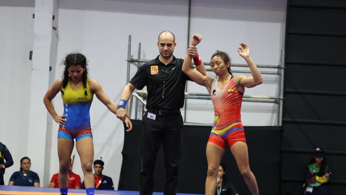 Jacqueline Mollocana (d), luchadora nacional, eleva sus brazos en señal de triunfo.