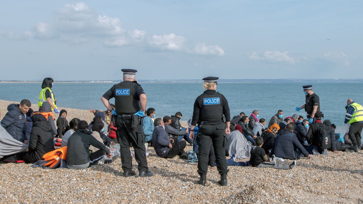 Oficiales de policía y de la institución de salvavidas junto a migrantes que fueron rescatados en el Canal de la Mancha, en Dungeness, Reino Unido, el 22 de septiembre.