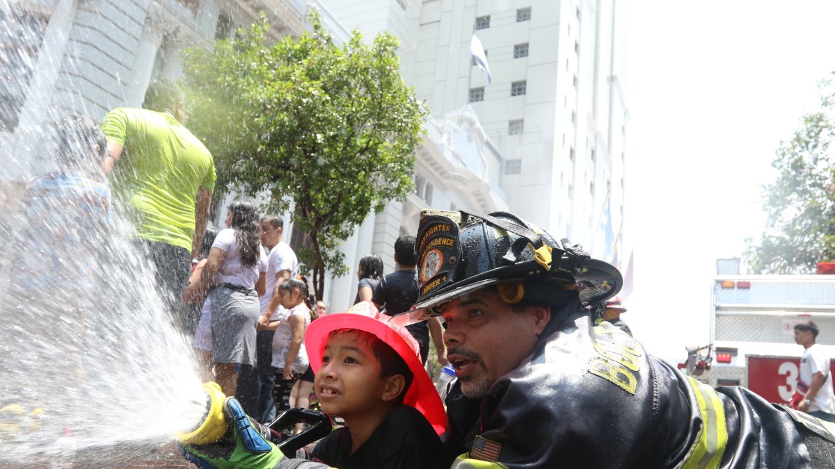 Los bomberos enseñaron a los niños a manejar una manguera para apagar un incendio.