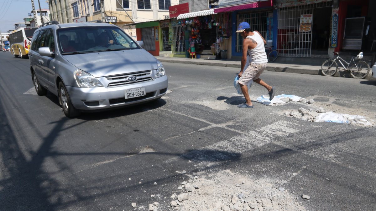 Andrés Romero coloca material de construcción en los huecos que se han formado en la avenida Laurice Anton. Una labor que realiza cada cuatro días.
