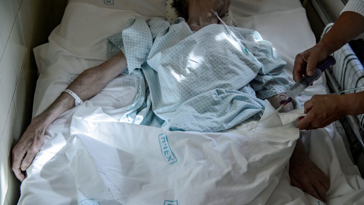 Un profesional sanitario alimenta a un paciente a través de una sonda en el Departamento de Cuidados Paliativos del Hospital Markhot Ferenc en Eger, en Hungría, el 27 de septiembre de 2019.