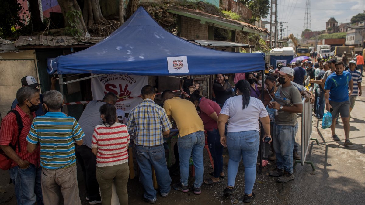 U grupo de personas mientras reciben ayuda gubernamental en una barriada afectada por lluvias, en Las Tejerías (Venezuela). EFE/ 