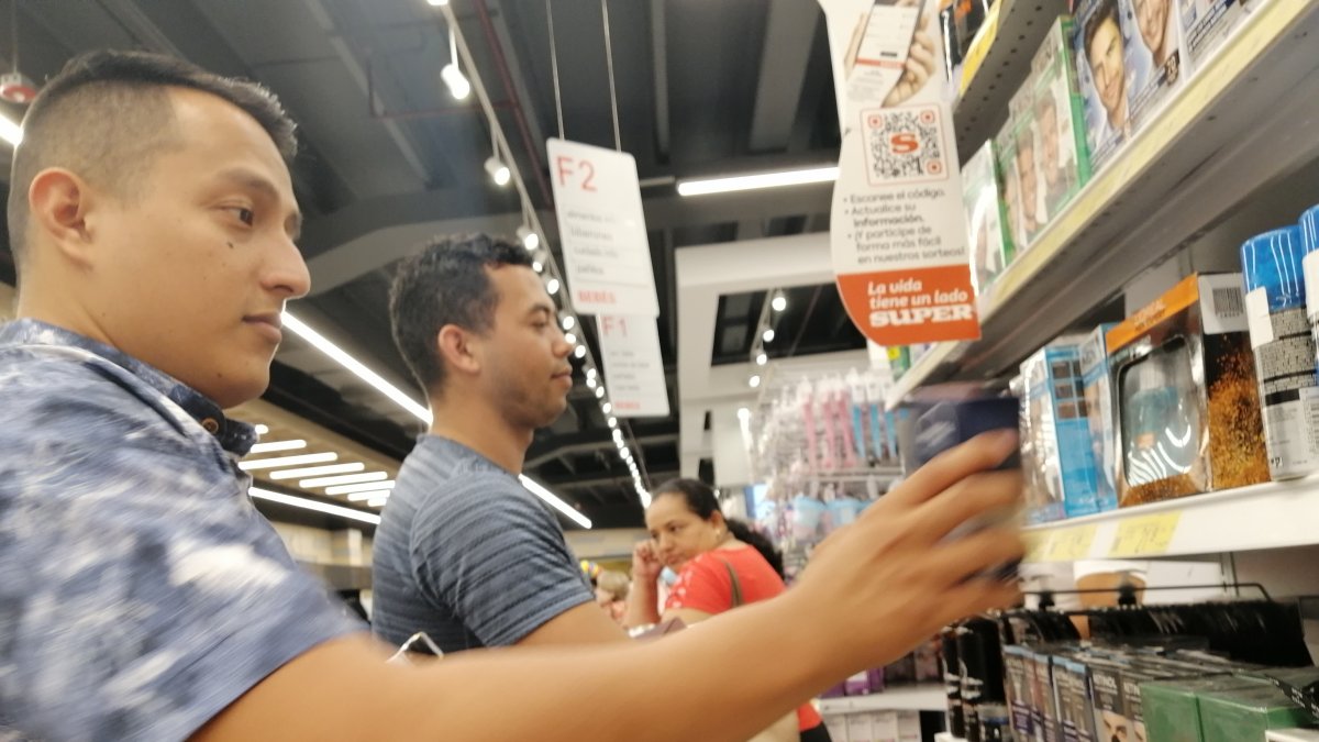 Clientes. Ostin Díaz y Erick Suri revisan y cotizan productos en perchas del Megamaxi.