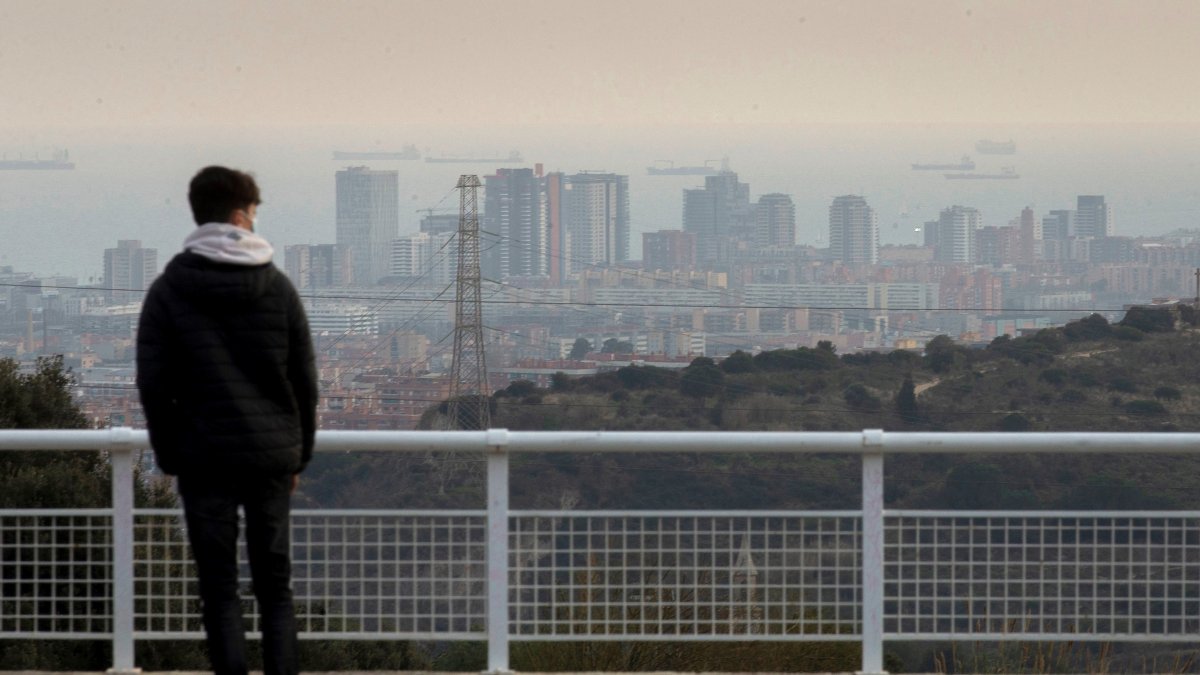 Vista de marzo de 2021 de una persona joven observando el paisaje de Barcelona.