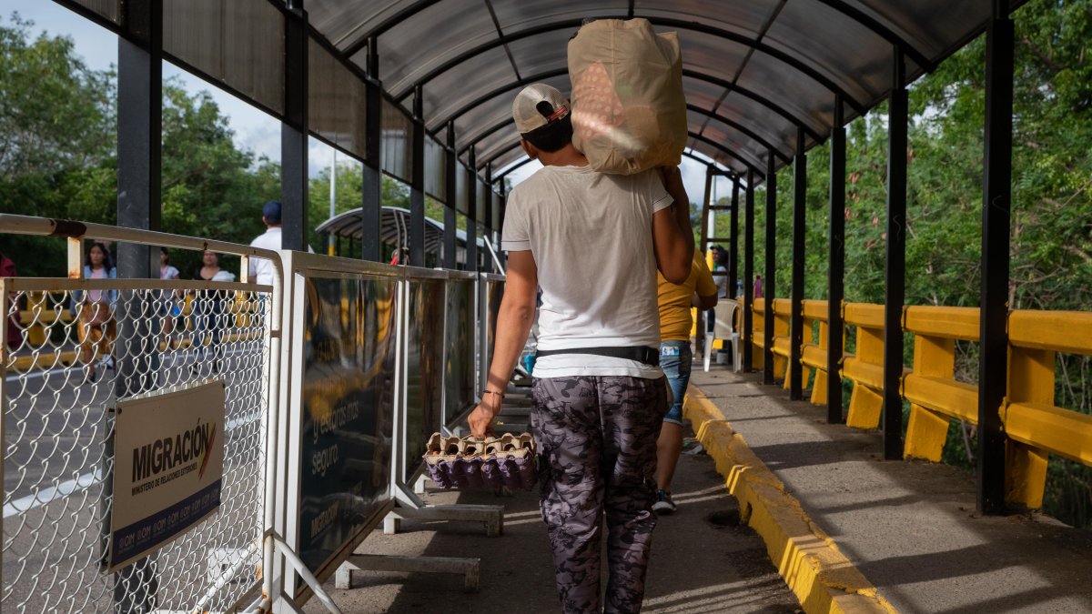 Un hombre mientras carga un mercado por el Puente Internacional Simón Bolívar, Cúcuta, Norte de Santander (Colombia). /Rayner Peña R.