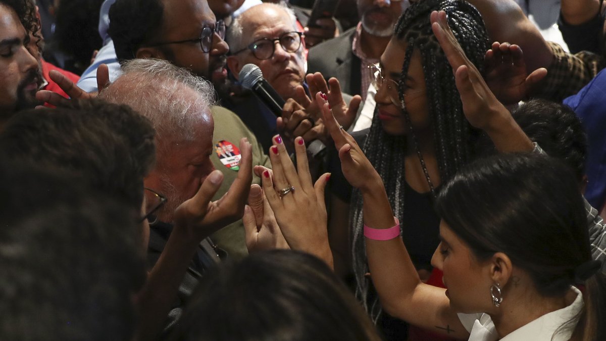 El expresidente y candidato Luiz Inácio Lula da Silva mientras recibe una oración de sus seguidores, en Sao Paulo (Brasil).   /Sebastião Moreira