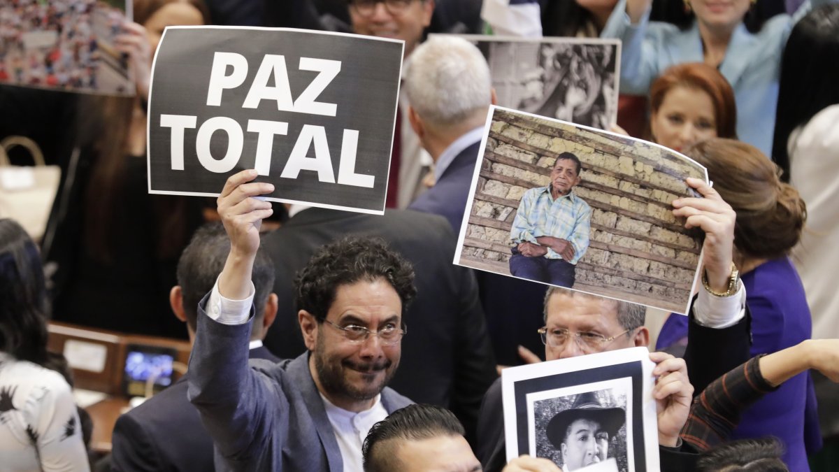 El senador colombiano Iván Cepeda (i), mientras sostiene un cartel que dice 