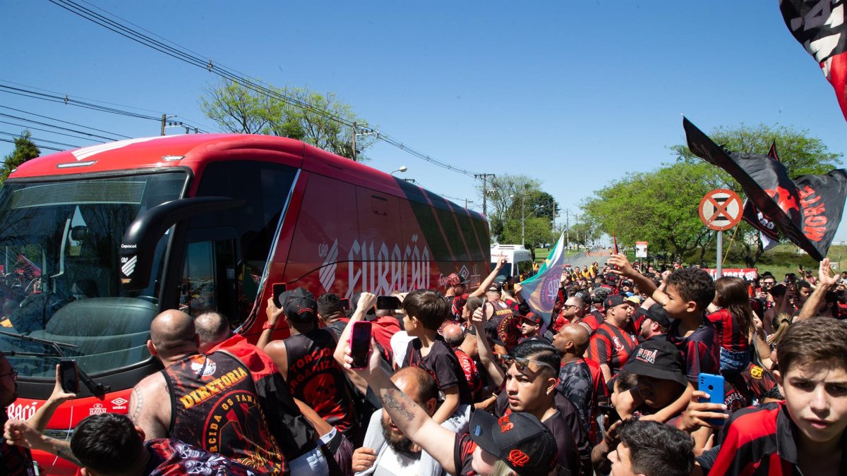 Aficionados del Atlético Paranaense acompañan a los jugadores previo a su viaje a Guayaquil para disputar la final de la Copa Libertadores ante Flamengo, hoy, en el Aeropuerto Internacional Afonso Pena, en São José dos Pinhais (Brasil).