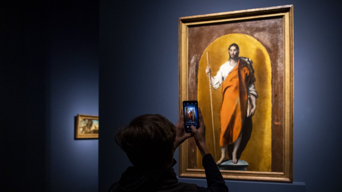 Un visitante toma una foto de la pintura 'Santiago el Mayor', que forma parte de la exposición 'El Greco' en el Museo de Bellas Artes de Budapest, que este viernes abre sus puertas.