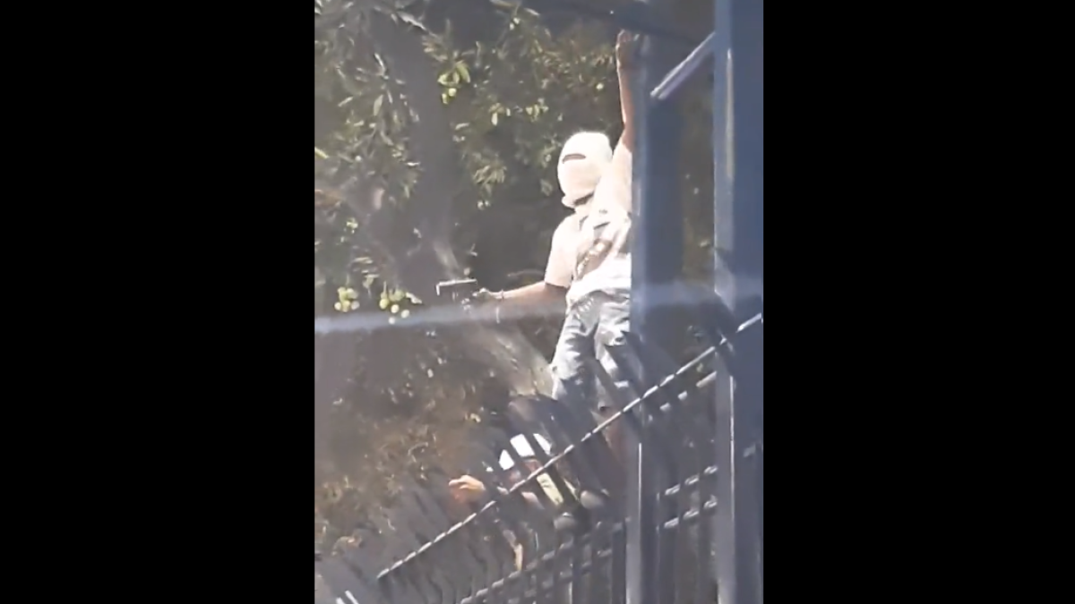 Momentos en que el hombre bailaba con una aparente arma de fuego en la reja de un sector del Malecón 2000.