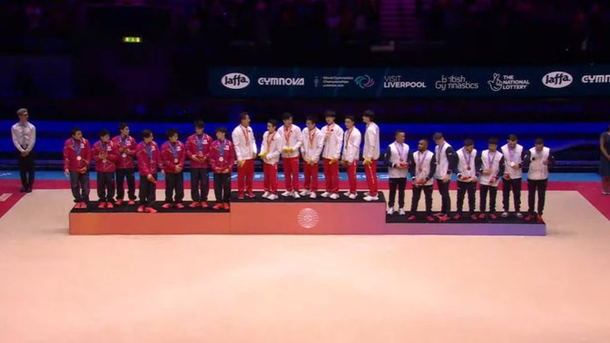 El equipo chino masculino de gimnasia artística junto a los representativos de Japón y Gran Bretaña.