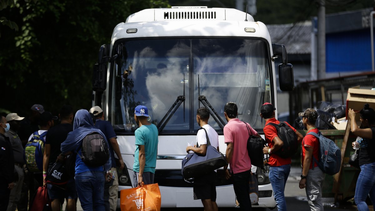 - Personas migrantes de origen venezolano hacen fila para subir a un autobús dirección aeropuerto internacional de Tocumen, en Ciudad de Panamá   EFE/ 