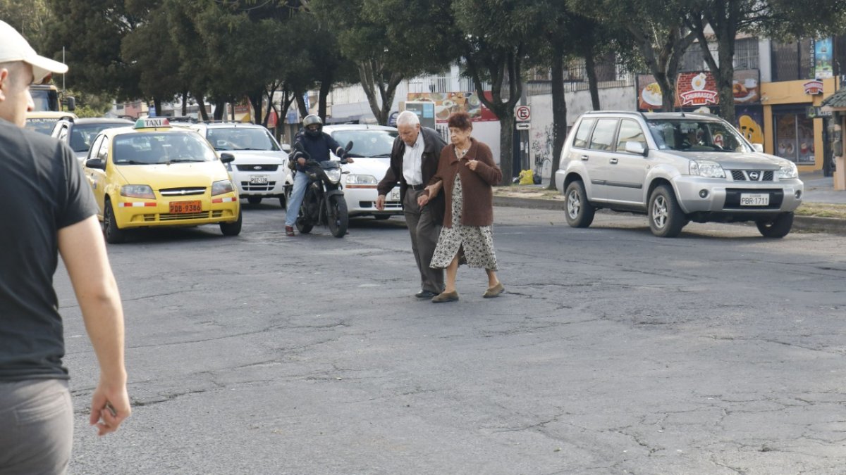 Irrespeto. Una pareja de la tercera edad cruzó la avenida Eloy Alfaro por donde mejor pudo. No existe ni siquiera un paso cebra trazado en la vía.