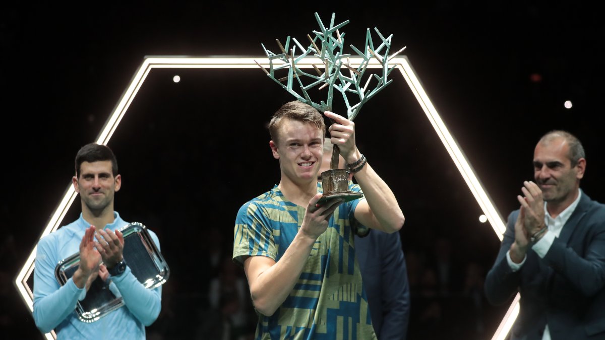 Holger Rune (C) levanta el título del Master 1.000 ante la mirada de Djokovic, atrás.