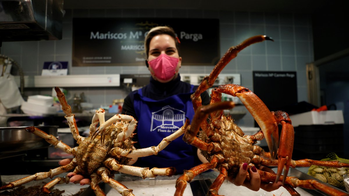 En la imagen de archivo, una trabajadora del mercado muestra dos ejemplares de centollo.