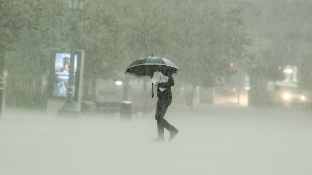 Estado. Un hombre camina bajola intensa lluvia en Valencia. La tormenta asociada a la DANA está provocando lluvias de intensidad muy fuerte en algunas zonas del oeste y sur del área metropolitana.