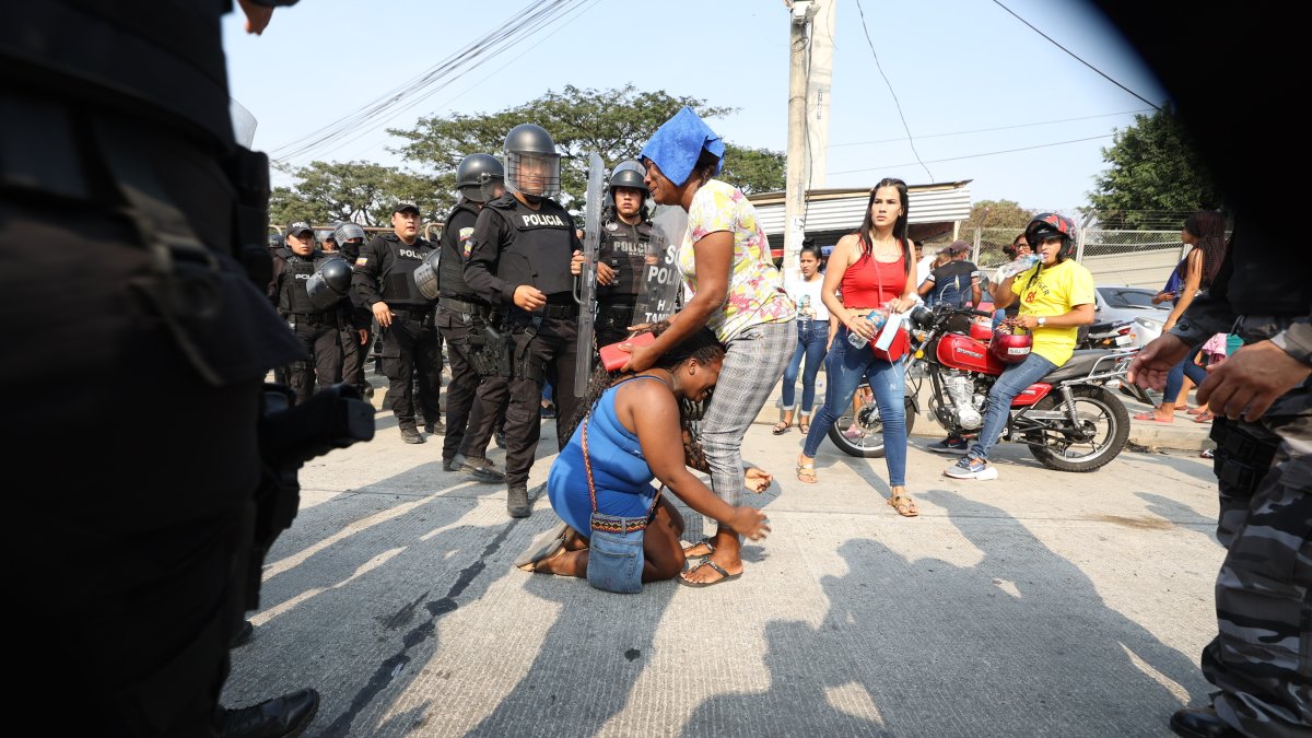 Familiares de internos tratan de consolorase mutuamente en medio del ambiente de caos que se registra en los exteriores de la Penitenciaría del Litora, durante una nueva jornada de enfrentamientos con muertes al interior de ese centro carcelario.