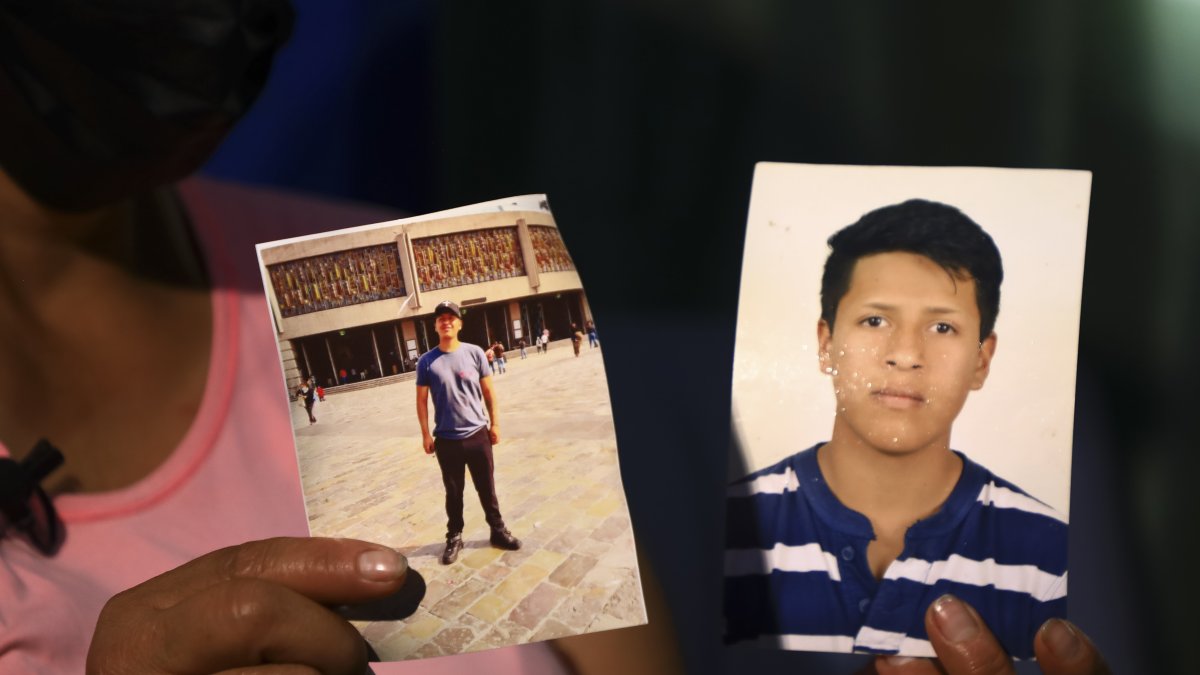 La madre de Adrián Tacuri sostiene una foto de su hijo el 28 de septiembre de 2022, en Cuenca (Ecuador).