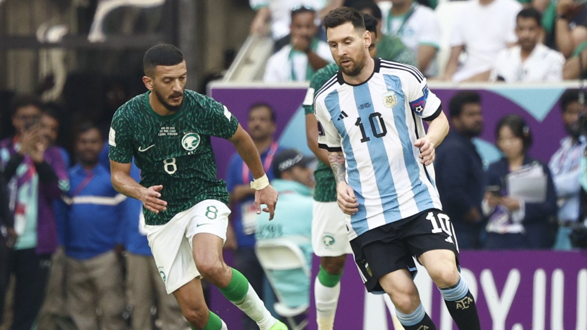Lionel Messi de Argentina disputa un balón con Abdulelah Almalki de Arabia Saudita