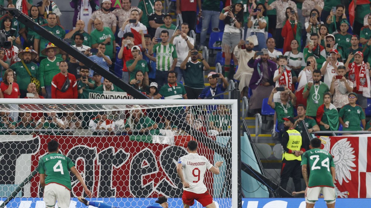 Guillermo Ochoa (c) México ataja un penalti a Robert Lewandowski (i) de Polonia hoy.