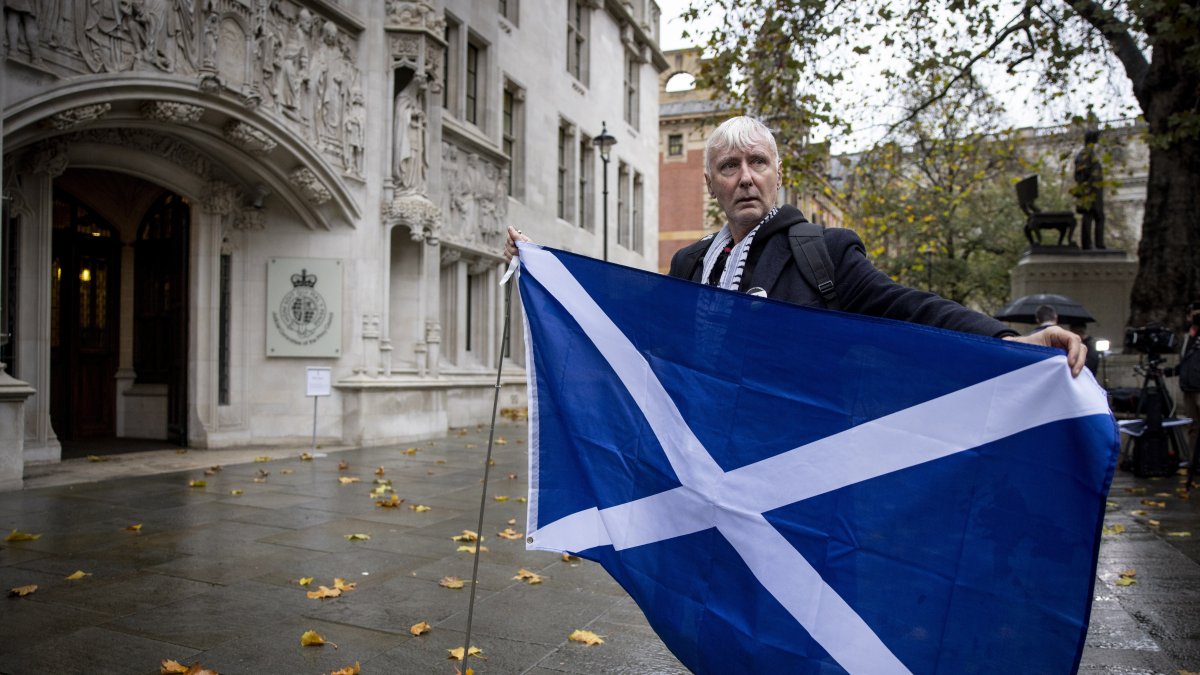 Un activista sostiene una bandera escocesa frente a la Corte Suprema del Reino Unido en Londres el 23 de noviembre de 2022. EFE /TOLGA AKMEN