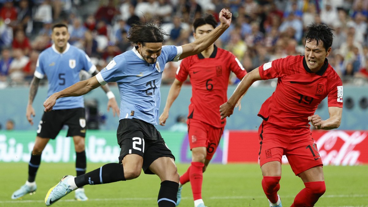 Edinson Cavani (i) de Uruguay disputa un balón con Kim Young-gwon de Corea del Sur hoy, en un partido de la fase de grupos del Mundial de Fútbol Qatar 2022 entre Uruguay y Corea del Sur en el estadio Ciudad de la Educación en Rayán (Qatar).