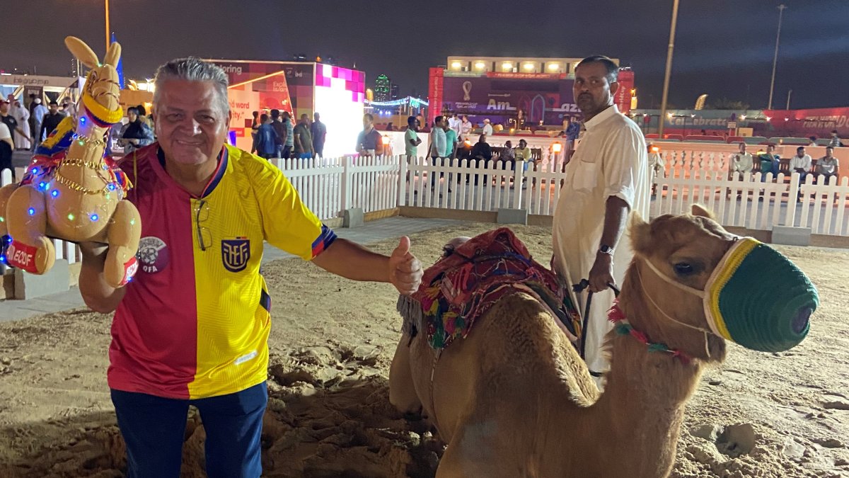 El hincha tricolor, Ecuador Echeverría, posa con un camello junto al suyo de juguete.