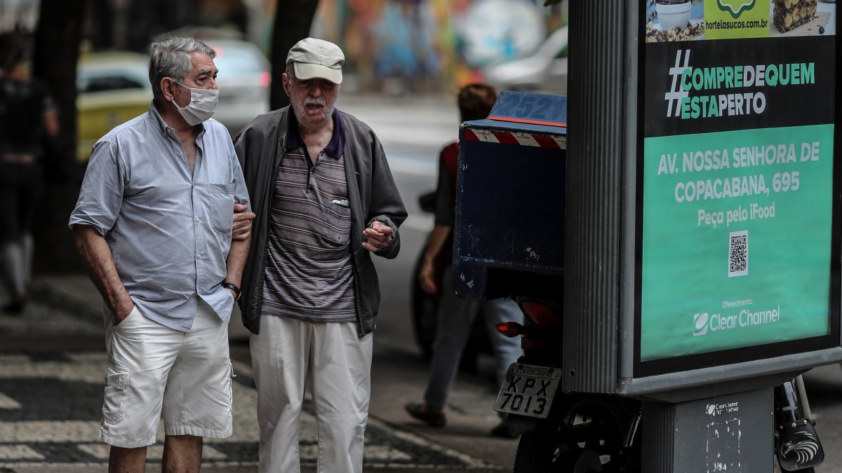 Un adulto mayor ayuda a caminar a un anciano, en Río de Janeiro (Brasil), en una fotograía de archivo.